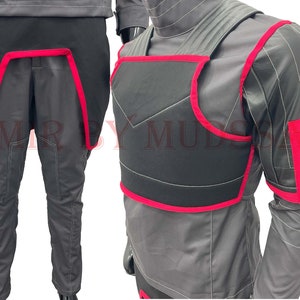 May include: A black and gray jumpsuit with red trim. The jumpsuit has a black chest piece with red trim and a black back piece with red trim. The jumpsuit is made of a soft, comfortable material.