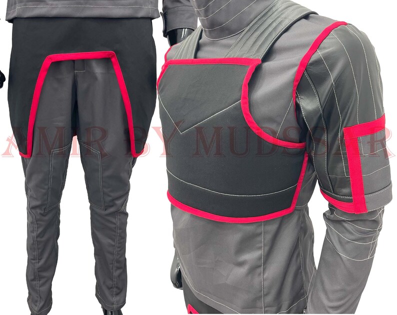 May include: A black and gray jumpsuit with red trim. The jumpsuit has a black chest piece with red trim and a black back piece with red trim. The jumpsuit is made of a soft, comfortable material.