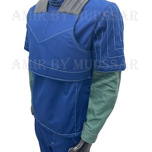 May include: A blue jumpsuit with a black vest and a green undershirt. The vest has a padded front and a black strap across the shoulders. The jumpsuit has white stitching details.