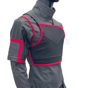 May include: A gray and black vest with red trim. The vest has a high collar and a zipper closure. It is made of a durable fabric and has a padded chest area.