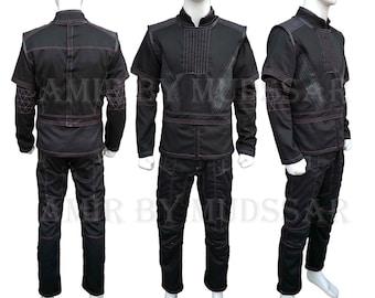 May include: Black and pink jumpsuit with a long-sleeved top and pants. The top has a high collar and a zipper closure. The pants have a straight leg and a zipper fly.
