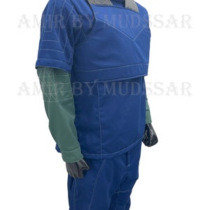 May include: A blue jumpsuit with a vest and white stitching. The vest has a gray panel across the shoulders. The jumpsuit has a high collar and short sleeves.