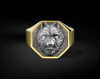 May include: A gold-toned ring with an octagonal face featuring a detailed silver wolf head. The wolf's fur is textured, and the ring has a polished finish. The ring is set against a black background.