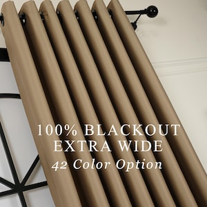 May include: Beige blackout curtains with eyelet rings, suspended from a black curtain pole. The image text states "100% BLACKOUT EXTRA WIDE 42 Color Option". These curtains are designed to block light.