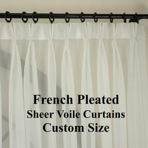 May include: Sheer white French pleated voile curtains hanging from a black rod with rings. The curtains are gathered at the top, creating vertical folds. Text on the image reads "French Pleated Sheer Voile Curtains Custom Size."