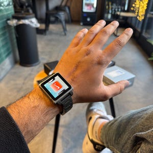 Könnte beinhalten: Ein Set aus drei Keramikbechern mit einer gesprenkelten, cremefarbenen Glasur. Jeder Becher hat ein anderes handgemaltes Blumendesign in Blau-, Grün- und Gelbtönen. Die Becher haben eine schlichte, moderne Form.