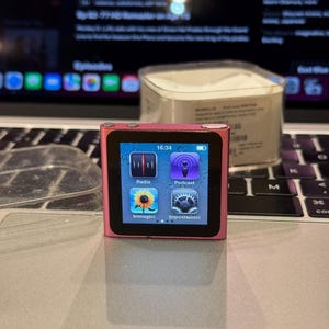 Könnte beinhalten: Eine weiße Keramik-Tasse mit schwarzem Henkel und dem Text "But first, coffee" in handschriftlichem Stil. Die Tasse steht auf einer weißen Oberfläche. Die Tasse ist wahrscheinlich für Heißgetränke.