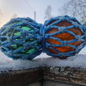 Small BØYEKAVL consisting of two glass fishing floats in the same net. Duo of a green and a brown norwegian vintage working glass float