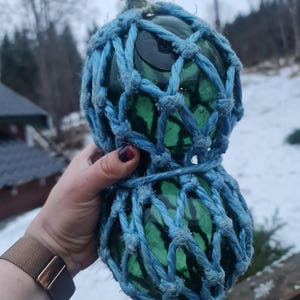Small BØYEKAVL consisting of two glass fishing floats in the same net. Duo of green authentic norwegian vintage working floats. Handblown