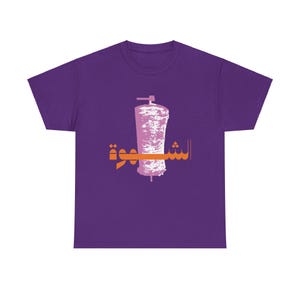 May include: Purple t-shirt with a graphic of a shawarma meat rotating on a spit. The Arabic text "Shawarma" is printed in orange on the shirt.