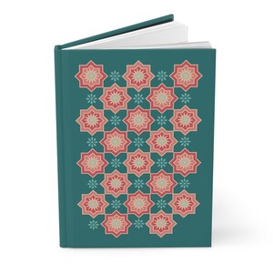 May include: A teal blue hardcover journal with a repeating pattern of red and peach eight-pointed stars on the front cover.