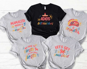 May include: Five gray and black t-shirts with colorful text and graphics. The shirts feature phrases like "Mamacita Needs a Margaritas", "Adios Bitchachos", "Tacos & Tequila", "No Time to Siesta It's My Final Fiesta", and "Let's Get Smashed".