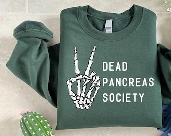 May include: A dark green sweatshirt with a white skeleton hand making a peace sign and the text "Dead Pancreas Society".