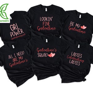 May include: Black t-shirts with various pink text designs. The designs include phrases like "GRL POWER," "LOOKIN' FINE Galentine," "BE MY Galentine," "ALL I NEED ARE MY Galentine's," "Galentine's SQUAD," and "LADIES Celebrating LADIES."