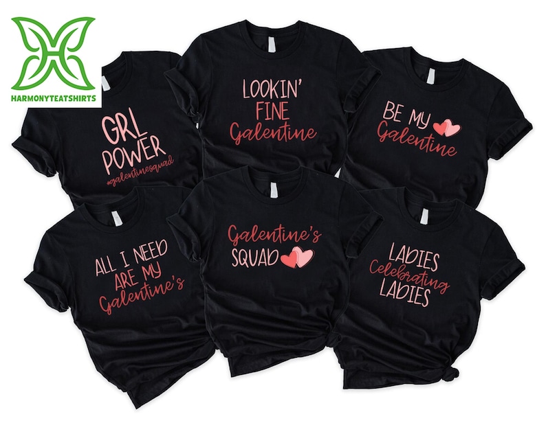 May include: Black t-shirts with various pink text designs. The designs include phrases like "GRL POWER," "LOOKIN' FINE Galentine," "BE MY Galentine," "ALL I NEED ARE MY Galentine's," "Galentine's SQUAD," and "LADIES Celebrating LADIES."