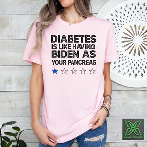 Op de afbeelding: Roze T-shirt met de tekst "Diabetes is alsof je Biden als pancreas hebt" en een beoordeling van &eacute;&eacute;n ster.