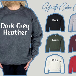 Może przedstawiać: Prezentowana jest ciemnoszara bluza z kapturem z wrzosu z napisem "Dark Grey Heather" w kolorze białym. Obraz przedstawia r&oacute;wnież tabelę kolor&oacute;w dla młodzieży z bluzami w kolorze czarnym, sportowym szarym, leśnym zielonym, bordowym, białym i czerwonym.