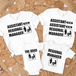 K&ouml;nnte beinhalten: Vier wei&szlig;e T-Shirts und ein Body mit schwarzem Text. Die Shirts tragen die Aufschrift "Assistent des Regionalleiters", "Assistent des Assistenten des Regionalleiters" und "Regionalleiter". Der Body tr&auml;gt die Aufschrift "The Boss".