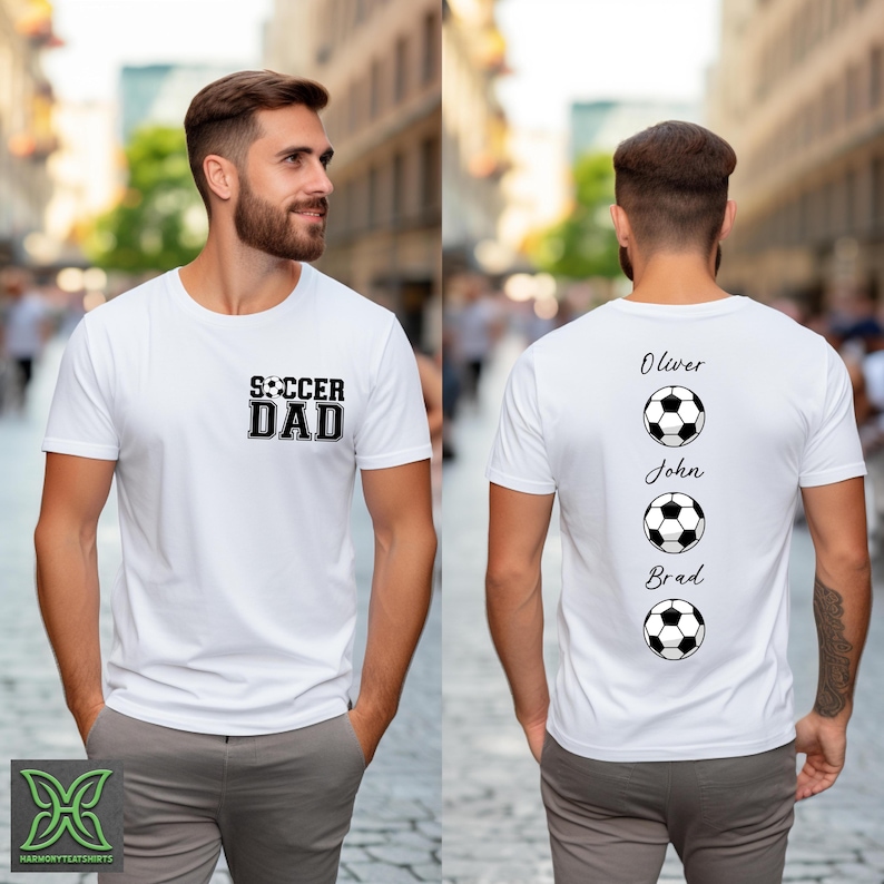 Peut inclure: T-shirt blanc avec l'inscription "SOCCER DAD" sur le devant et les noms Oliver, John et Brad avec des graphiques de ballon de football au dos. Le t-shirt est de style col rond et est fait d'une mati&egrave;re douce.