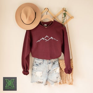 a sweater and hat are hanging on a wall