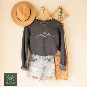 a pair of shorts, a hat, and a sweater hanging on a wall