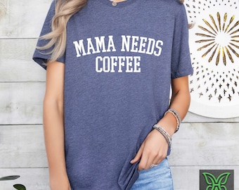 May include: A navy blue t-shirt with the text "Mama Needs Coffee" in white lettering.