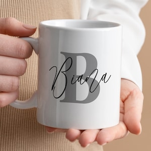 May include: White ceramic mug with a gray letter B and the name "Bianca" written in black cursive.