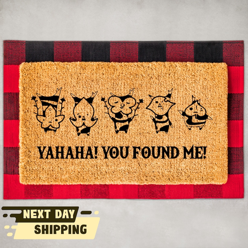 May include: A brown coir doormat with a black and white design of five cartoon characters and the text "YAHAHA! YOU FOUND ME!"