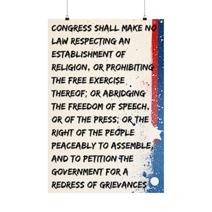 May include: A vertical poster featuring the text of the First Amendment in black, bold, sans-serif font on a cream background. The right side displays a vertical red and blue paint splatter design with a white star and a white circle at the bottom.
