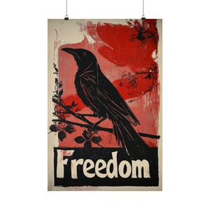 May include: A vertical rectangular poster featuring a black silhouette of a crow perched on a branch against a textured red background. Below the bird, a black horizontal block contains the white text Freedom in a bold, sans-serif typeface.