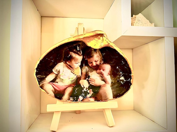 Happy moments captured on a shell. Your personal photo transferred into a shell, sealed with resin and displayed with a stand.