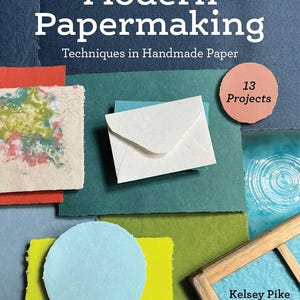 May include: A book titled Modern Papermaking: Techniques in Handmade Paper by Kelsey Pike, featuring a collection of colorful handmade paper samples in various shapes, a white envelope, and a wooden frame, with a label indicating 13 Projects.
