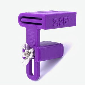 May include: A purple 3D-printed clamp with a rectangular top and a U-shaped base. The top is labeled "2.25"" and has two slots. A metal wing nut and bolt secure the clamp's components.