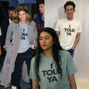 Könnte beinhalten: Drei Personen tragen T-Shirts mit dem Aufdruck "I told ya". Die Shirts sind in verschiedenen Farben: grau, weiß und grün.