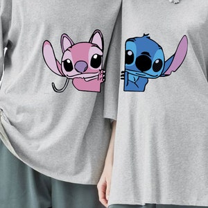 K&ouml;nnte beinhalten: Zwei graue T-Shirts mit Cartoon-Charakteren. Eines zeigt einen rosa Charakter mit gro&szlig;em Ohr, das andere einen blauen Charakter. Beide Charaktere l&auml;cheln. Die T-Shirts haben kurze &Auml;rmel.