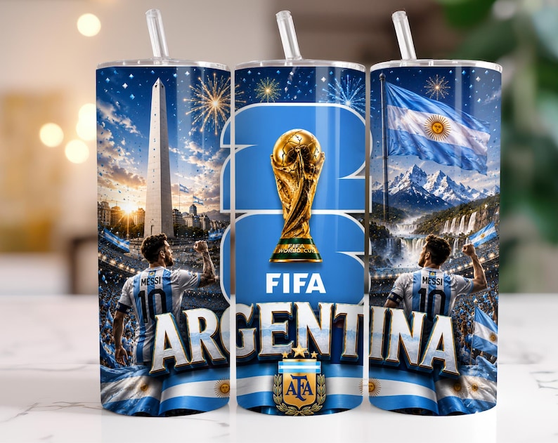 May include: A cylindrical tumbler with a straw featuring a graphic design of the FIFA World Cup trophy, the text "ARGENTINA" and "FIFA", the Obelisco de Buenos Aires, the Argentine flag, and a football player wearing a jersey with "MESSI 10".