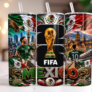 May include: A cylindrical tumbler with a straw featuring a graphic design of the FIFA World Cup trophy, the text 26, and MEXICO. The design includes the Mexican flag, a football player in a green jersey, a golden eagle, and architectural landmarks.