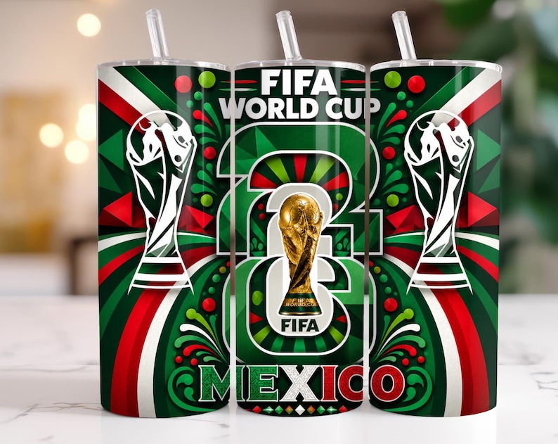 May include: A cylindrical tumbler with a straw featuring a FIFA World Cup theme. The design includes the gold FIFA trophy, the text FIFA WORLD CUP, and MEXICO in green, white, and red colours with geometric patterns and swirling accents.