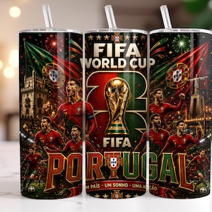 May include: A cylindrical tumbler with a straw featuring a FIFA World Cup graphic, the word PORTUGAL, and images of football players in red jerseys, the Portuguese flag, the Bel&eacute;m Tower, and the Christ the King statue against a dark, festive background.