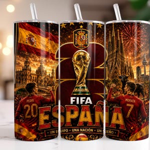 May include: A cylindrical tumbler with a straw featuring a graphic design of the Spanish national football team. It displays the FIFA World Cup trophy, the Spanish flag, football players Pedri and Morata, the Sagrada Familia, and the text FIFA ESPA&Ntilde;A.