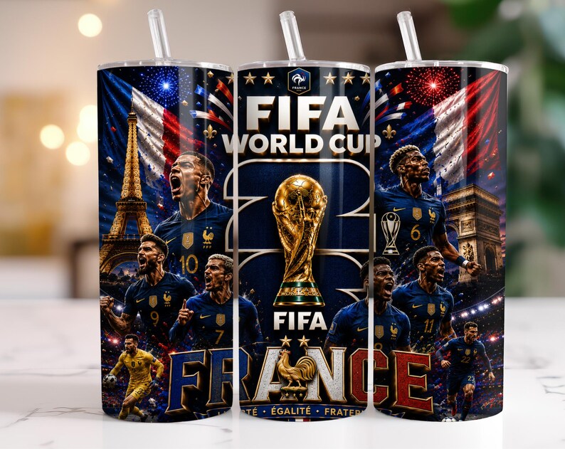 May include: A cylindrical tumbler with a straw featuring a FIFA World Cup graphic, the Eiffel Tower, the Arc de Triomphe, the French flag, and multiple football players in blue jerseys. The design includes the text FIFA WORLD CUP and FRANCE.