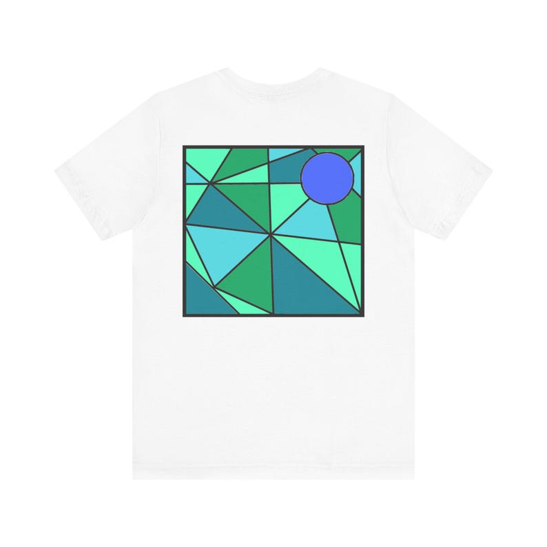 K&ouml;nnte beinhalten: Wei&szlig;es T-Shirt mit einem geometrischen Design in Gr&uuml;n-, Blau- und T&uuml;rkist&ouml;nen. Ein blauer Kreis befindet sich in der Mitte des Designs.