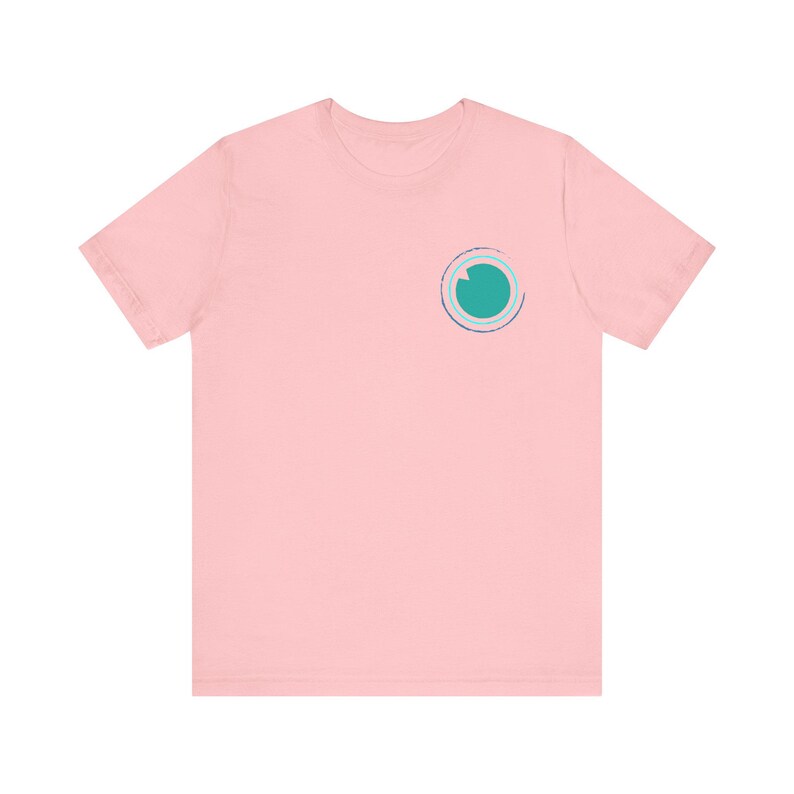 K&ouml;nnte beinhalten: Ein pinkfarbenes T-Shirt mit einem t&uuml;rkisfarbenen und blauen Kreisdesign auf der linken Brust.