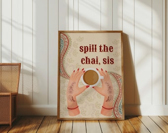 May include: A framed print with a beige background and a colorful paisley design. The print features a pair of hands holding a cup of chai tea with the text "spill the chai, sis" in red.