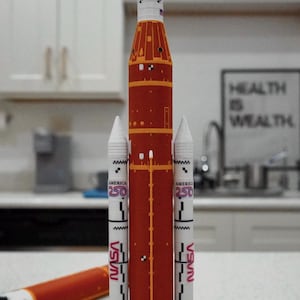 Puede incluir: Un letrero de madera hecho a mano con el texto "Welcome" en una fuente juguetona. El letrero presenta un fondo blanco desgastado y un borde marrón oscuro, perfecto para una puerta de entrada. Mide aproximadamente 30 cm de ancho.