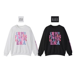 K&ouml;nnte beinhalten: Zwei lang&auml;rmelige Sweatshirts mit dem Text "In My Figure Skating Era" in einer bunten Retro-Schrift. Ein Sweatshirt ist aschgrau und das andere ist schwarz.