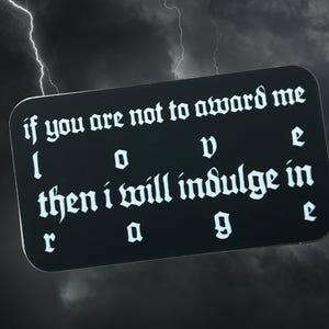 Puede incluir: Una pegatina rectangular negra con esquinas redondeadas, con letras góticas blancas. El texto dice: "if you are not to award me I O V e then i will indulge in r a g e." El fondo muestra un cielo tormentoso con relámpagos.