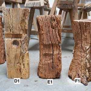 K&ouml;nnte beinhalten: Drei vertikale Holzbl&ouml;cke mit rauen, verwitterten Texturen und nat&uuml;rlichen Braunt&ouml;nen. Die Bl&ouml;cke sind mit D1, E1 und F1 beschriftet. Jedes St&uuml;ck weist einzigartige Maserungen, tiefe Risse und organische Formen auf, die ein rohes Aussehen zeigen.