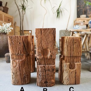 K&ouml;nnte beinhalten: Drei vertikale rechteckige Holzbl&ouml;cke mit den Bezeichnungen A, B und C. Jeder Block weist eine verwitterte, strukturierte braune Oberfl&auml;che mit tiefen vertikalen Maserungen und eine kreisf&ouml;rmige Vertiefung auf der Vorderseite auf.