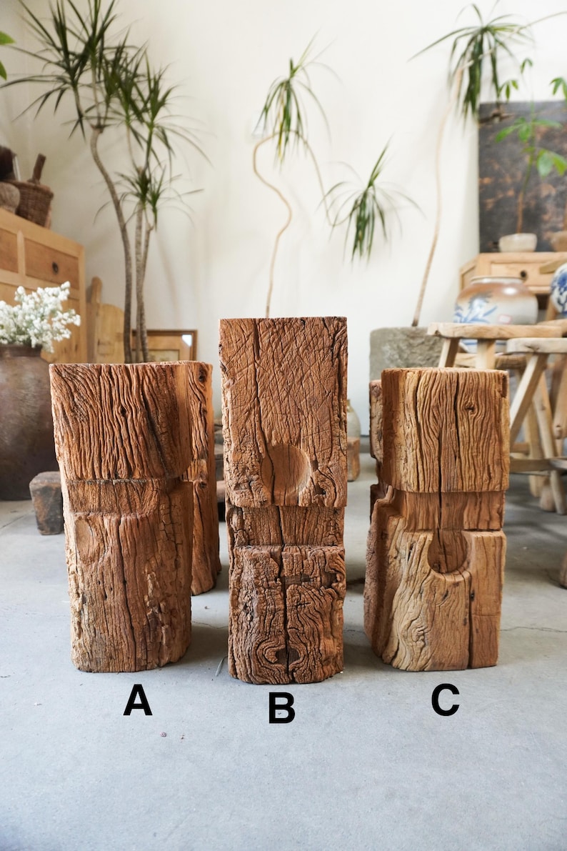 K&ouml;nnte beinhalten: Drei vertikale rechteckige Holzbl&ouml;cke mit den Bezeichnungen A, B und C. Jeder Block weist eine verwitterte, strukturierte braune Oberfl&auml;che mit tiefen vertikalen Maserungen und eine kreisf&ouml;rmige Vertiefung auf der Vorderseite auf.